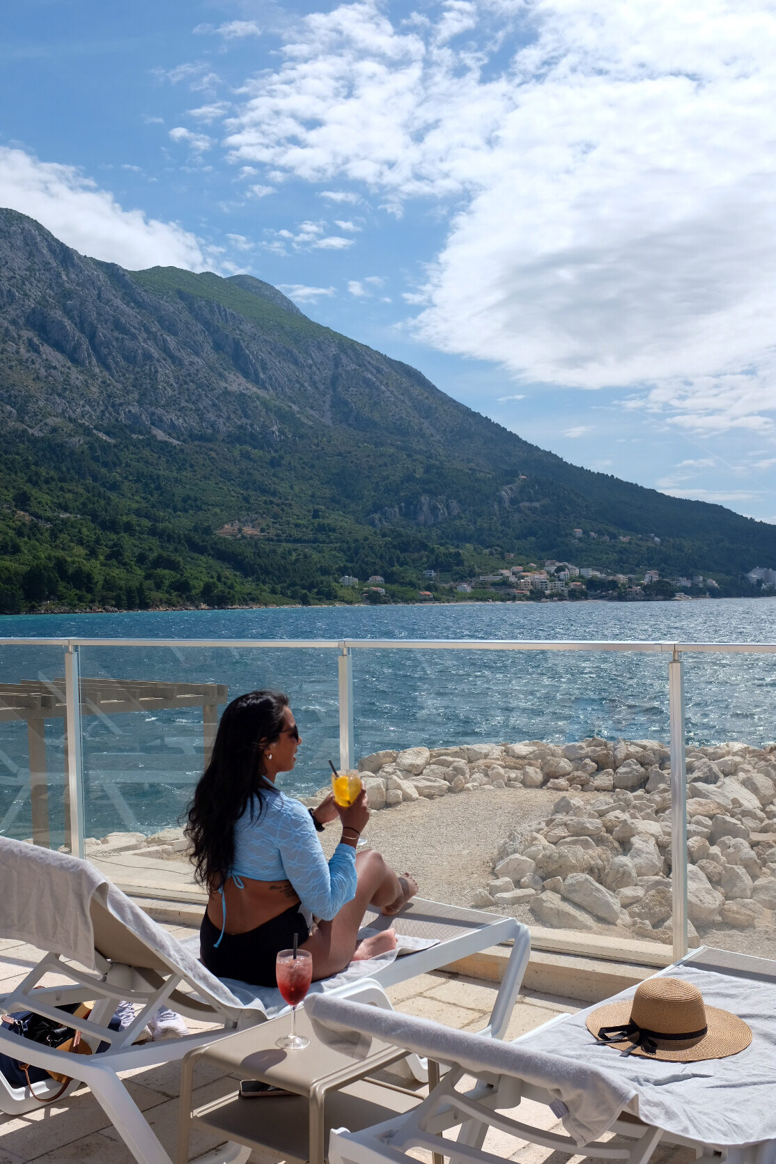 Portrait travel photo with a drink, mountains in the background