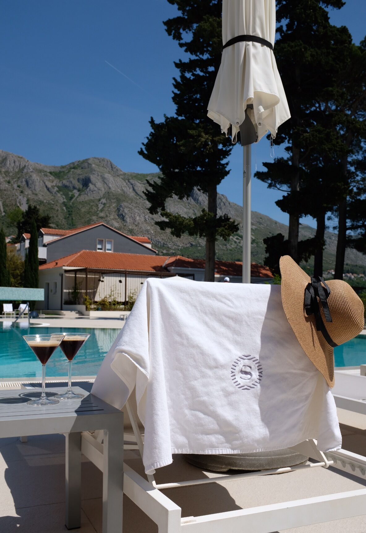 Poolside with towel and espresso martinis, mountains in the background