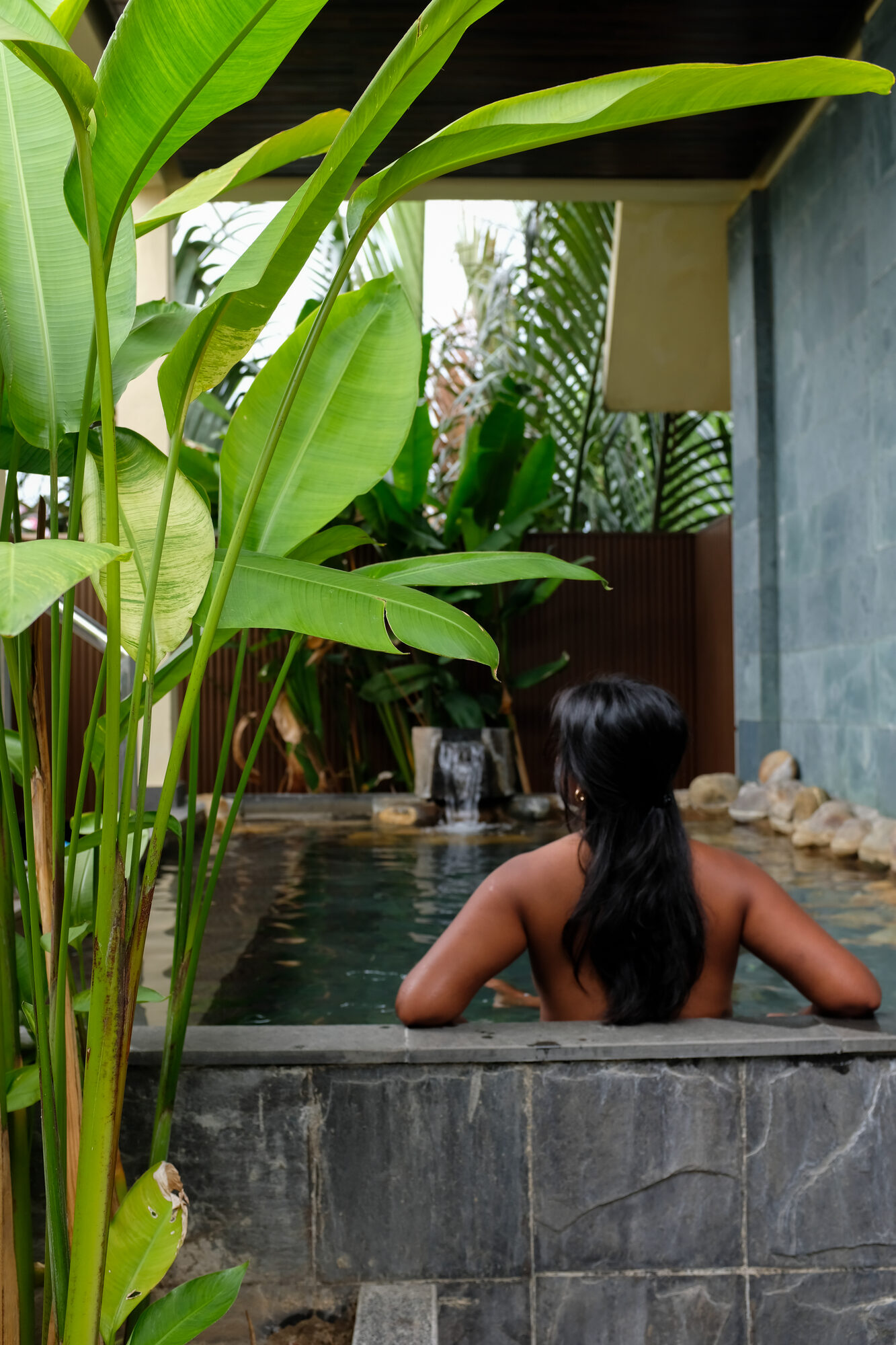 Relaxing in a tiled pool surrounded by tropical plants